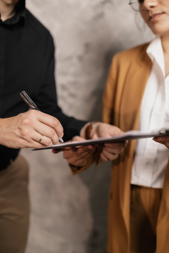 why-choose-us Close-up of two professionals signing a business document, emphasizing collaboration and negotiation.